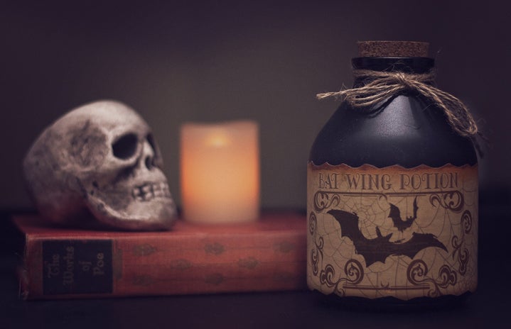 white skull on a book with a potion