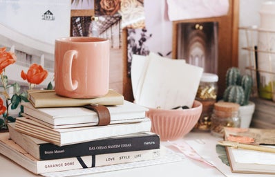 Pink desk with books and mug