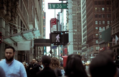 People walking in Times Square, a W 36 ST and a stop light in view