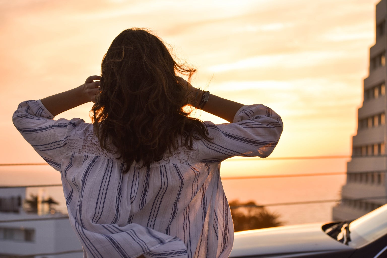 woman looking at sunset over water