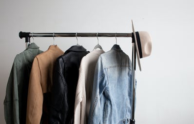 rack of clothes with five jackets and a hat