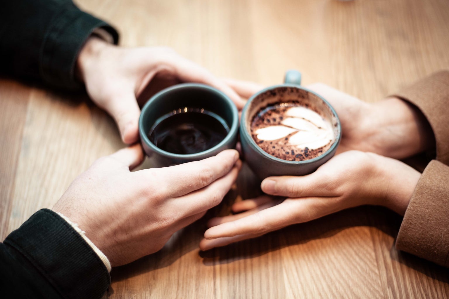 two cups of hot chocolate on table being held