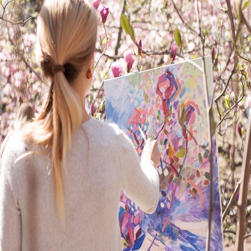 woman painting flowers outdoors