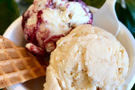 two scoops of ice cream with a waffle cone wedge
