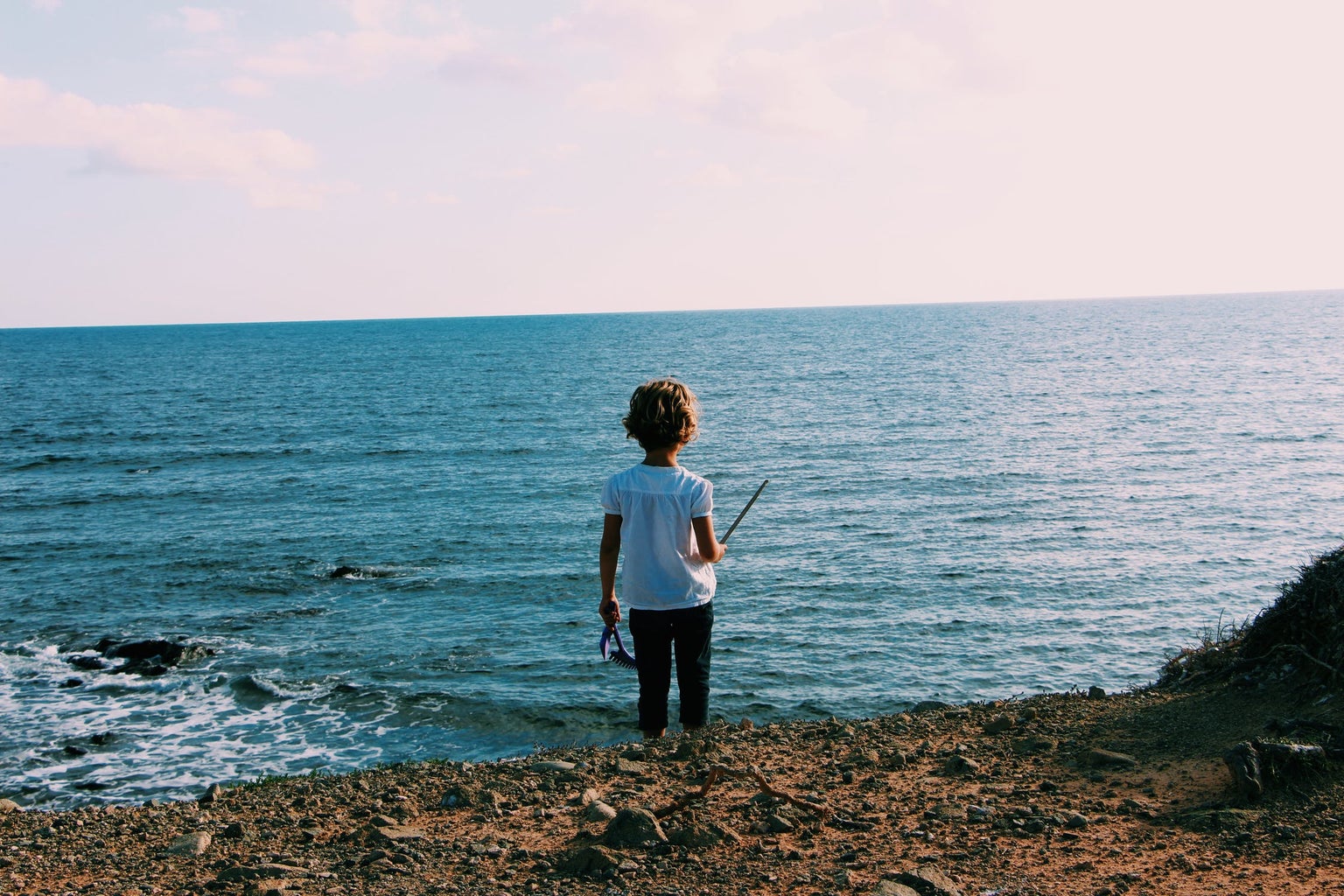 back view of a child standing on the shoreline