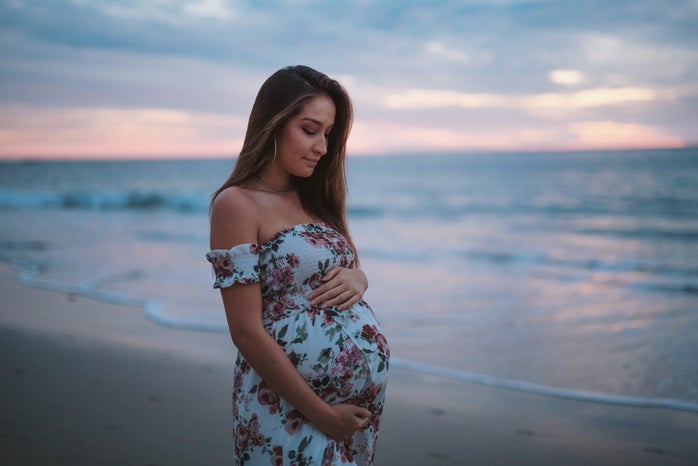 Pregnant woman on beach holding stomach by Neal Johnson on Unsplash?width=698&height=466&fit=crop&auto=webp