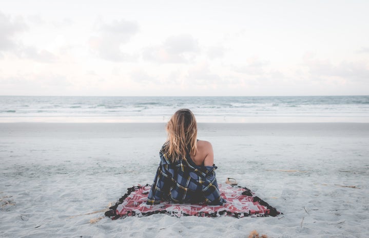 Woman sitting alone on beach