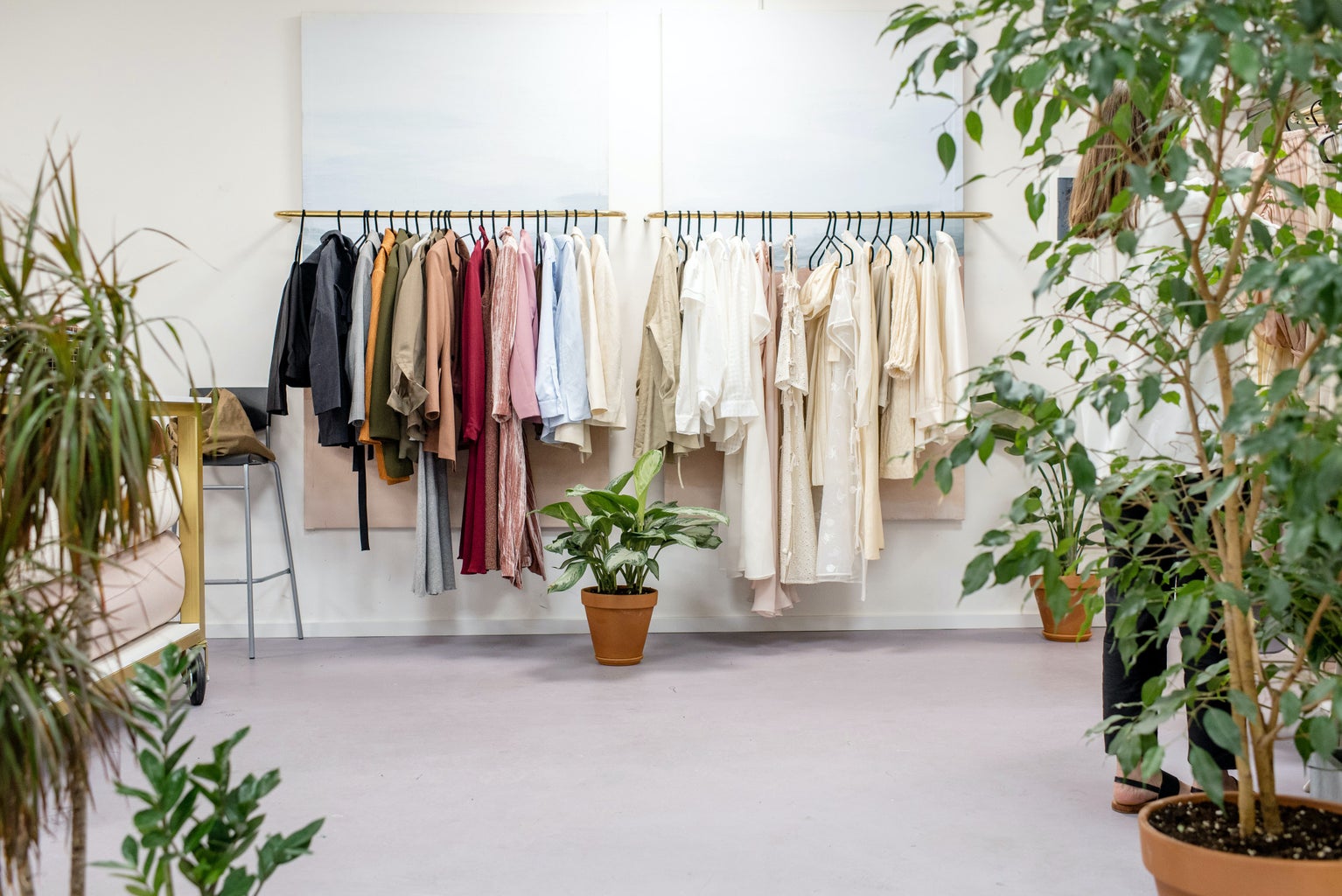 clothes on clothing rack surrounded by potted plants