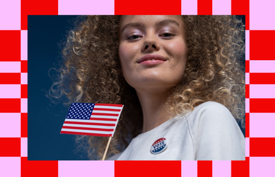 woman holding american flag with vote pin