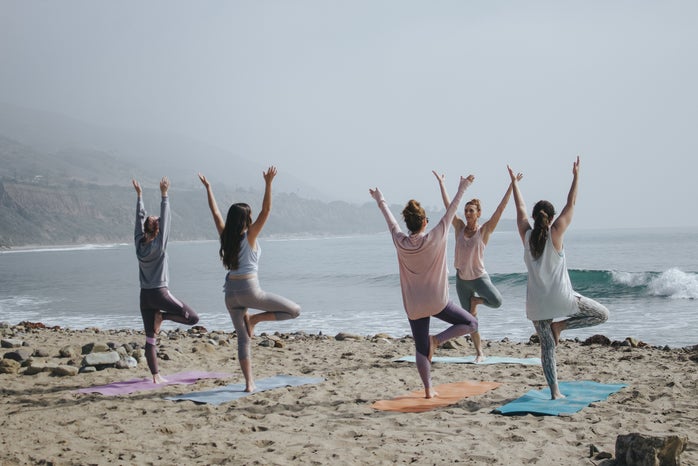 Women doing yoga on the beach by Kaylee Garrett via Unsplash?width=698&height=466&fit=crop&auto=webp