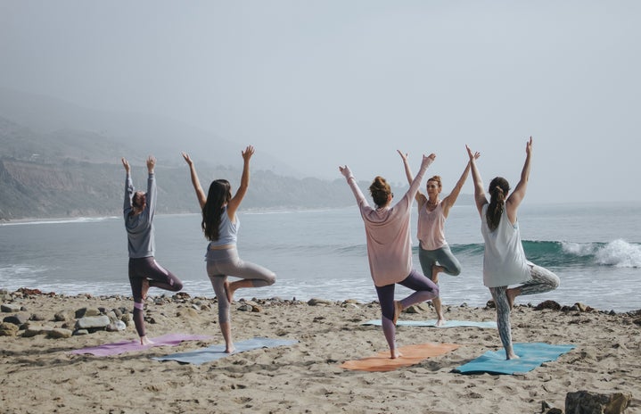 Women doing yoga on the beach by Kaylee Garrett via Unsplash?width=719&height=464&fit=crop&auto=webp