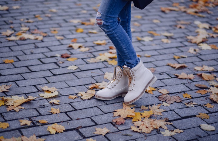 person wearing boots in fall leaves