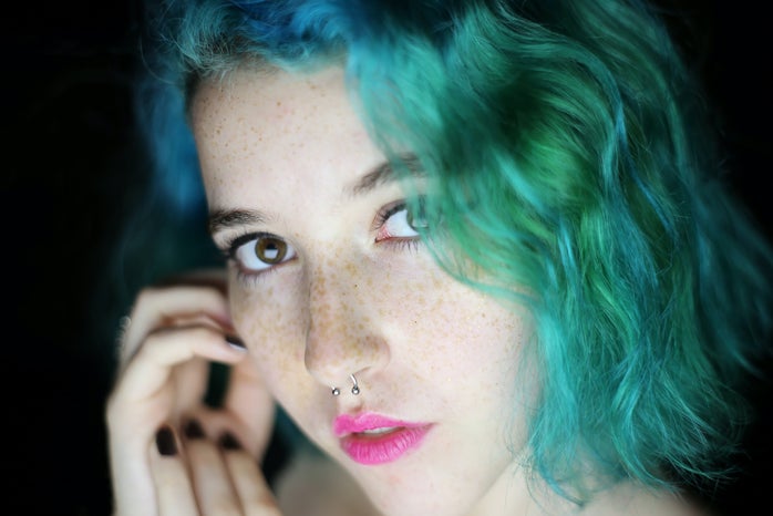Girl with blue-green hair and septum piercing