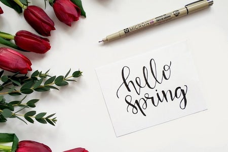 “Hello Spring” sign with pen and roses