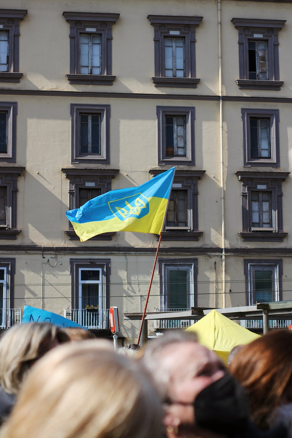 people outside, flying a Ukraine flag