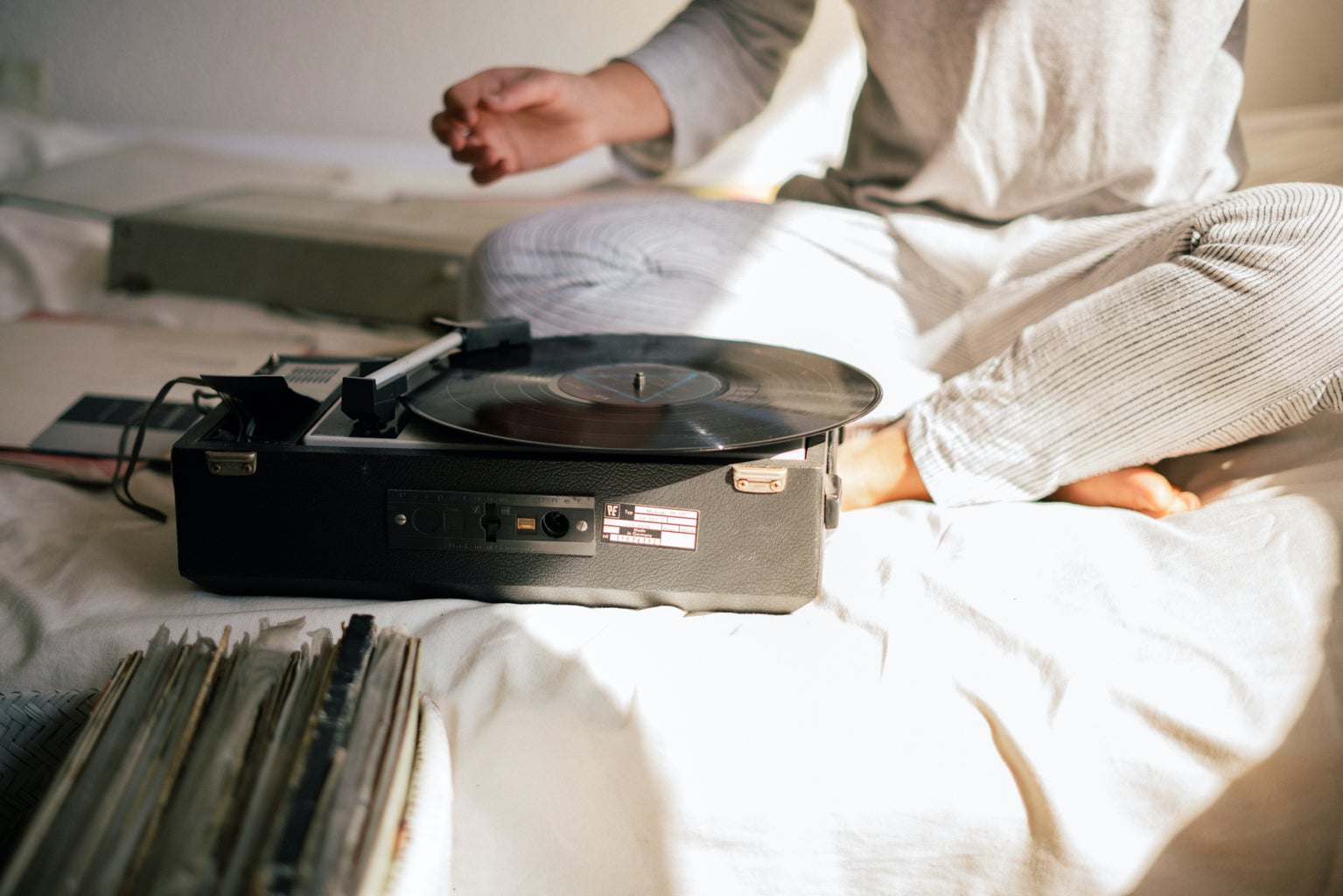 black record player on white bed sheets