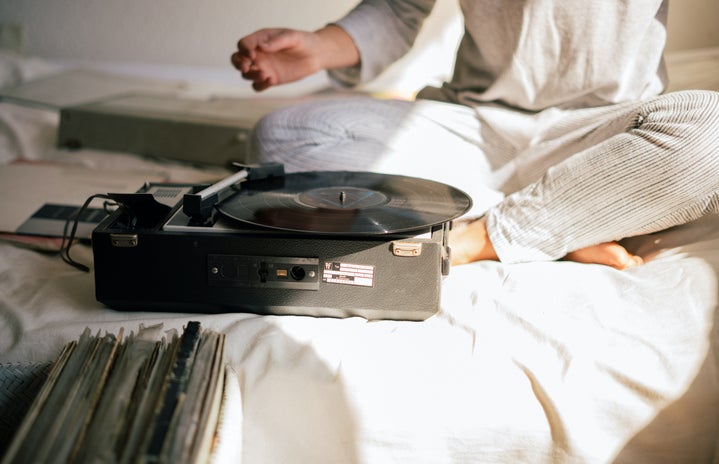 black record player on white bed sheets