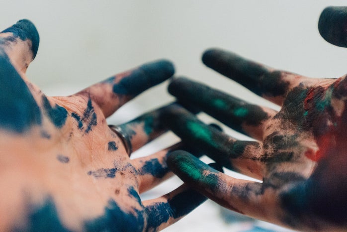 two hands covered in paint