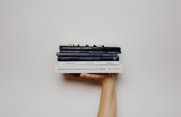 A pile of books in on person\'s hand