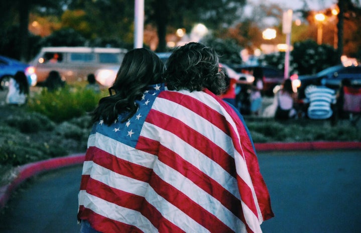 Two women wrapped in American flag by Courtney Hedger?width=719&height=464&fit=crop&auto=webp