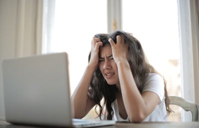 it shows a girl frustrated in front of her laptop