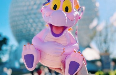 Figment popcorn bucket in front of Epcot’s Spaceship Earth