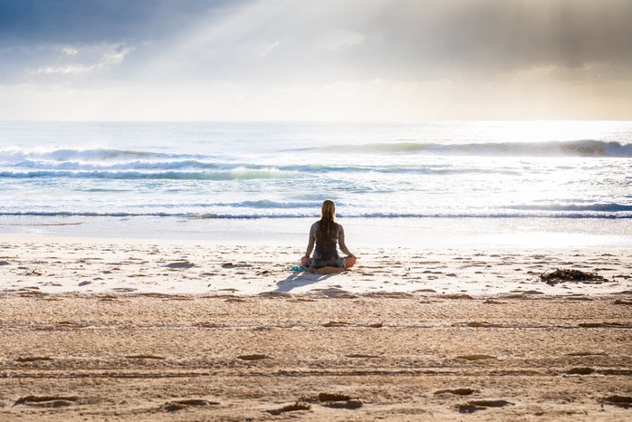woman meditating on beach by Unsplash?width=698&height=466&fit=crop&auto=webp