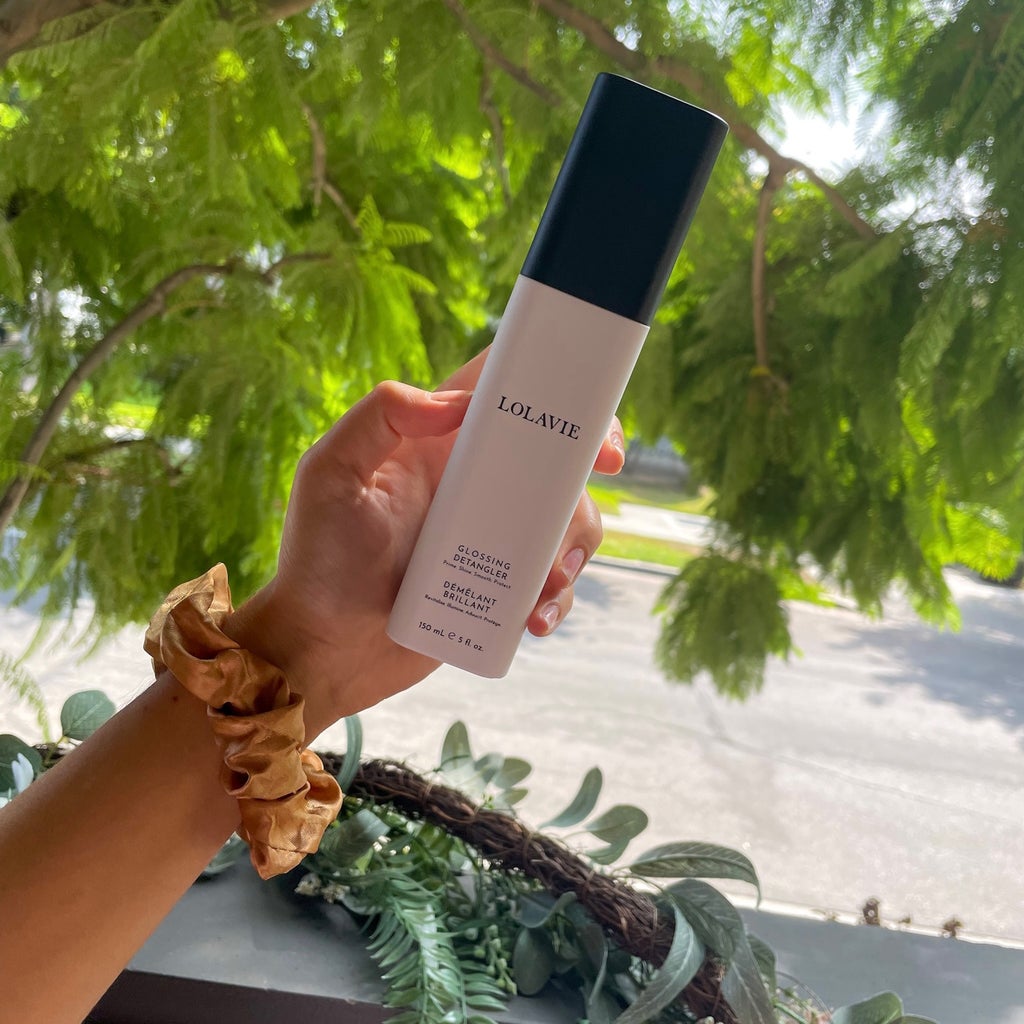 Arm holding haircare product: LolaVie The Glossing Detangler