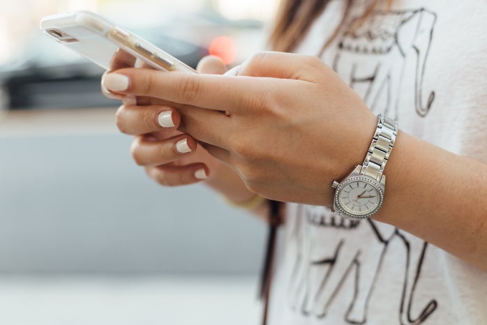 woman holding phone wearing watch