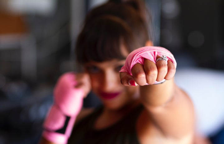 woman punching with pink wrist wraps on by Sarah Cervantes?width=719&height=464&fit=crop&auto=webp