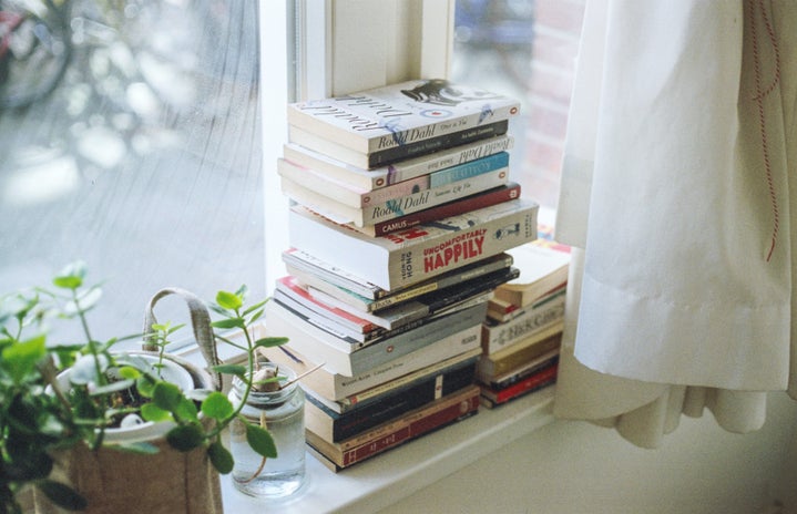 a stack of books on a window shelf by Florencia Viadana?width=719&height=464&fit=crop&auto=webp