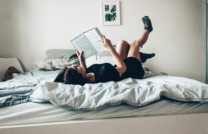 woman reading while laying in bed