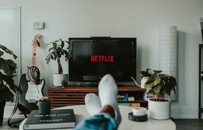 person watching Netflix with feet on white table