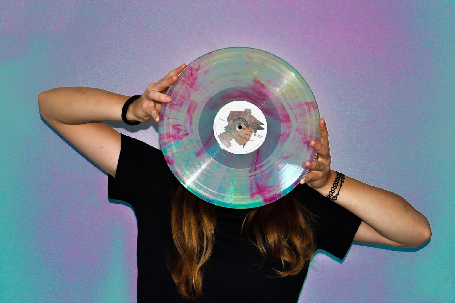 Girl with record covering her face