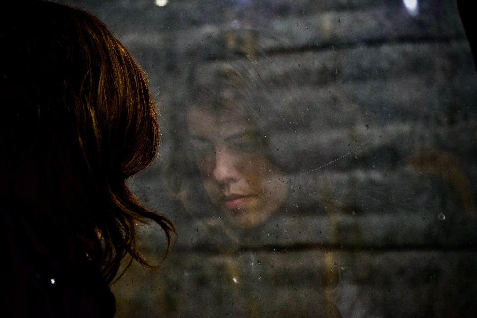Woman staring at a window sadly
