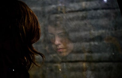 Woman staring at a window sadly