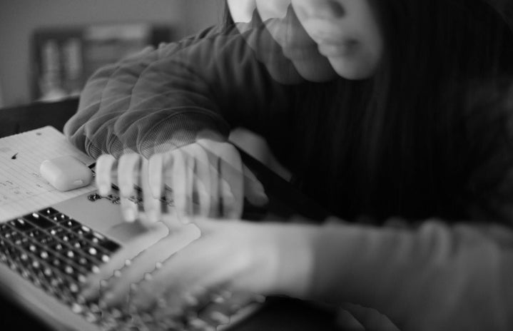 Girl is typing at a computer, but editting makes it seem like there are multiple hands in a blurried motion