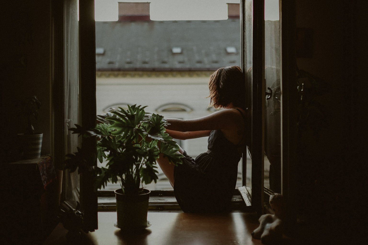 woman leaning on door looking out onto the city