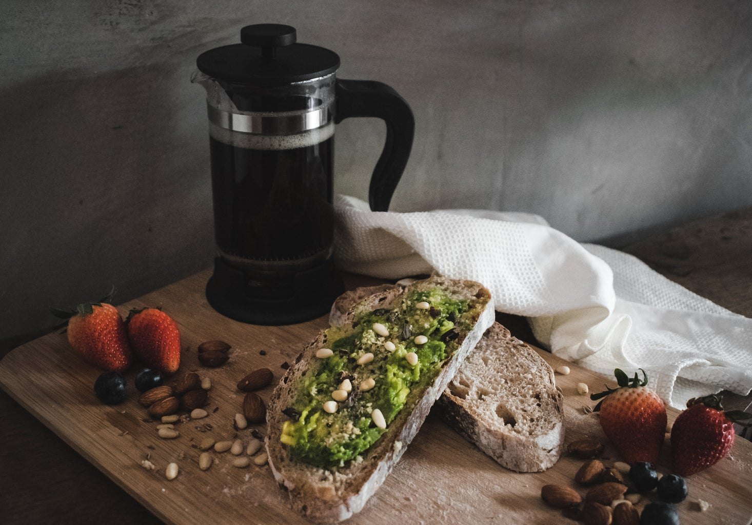 Avocado toast, fruits and nuts, and coffee.