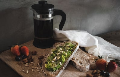 Avocado toast, fruits and nuts, and coffee.