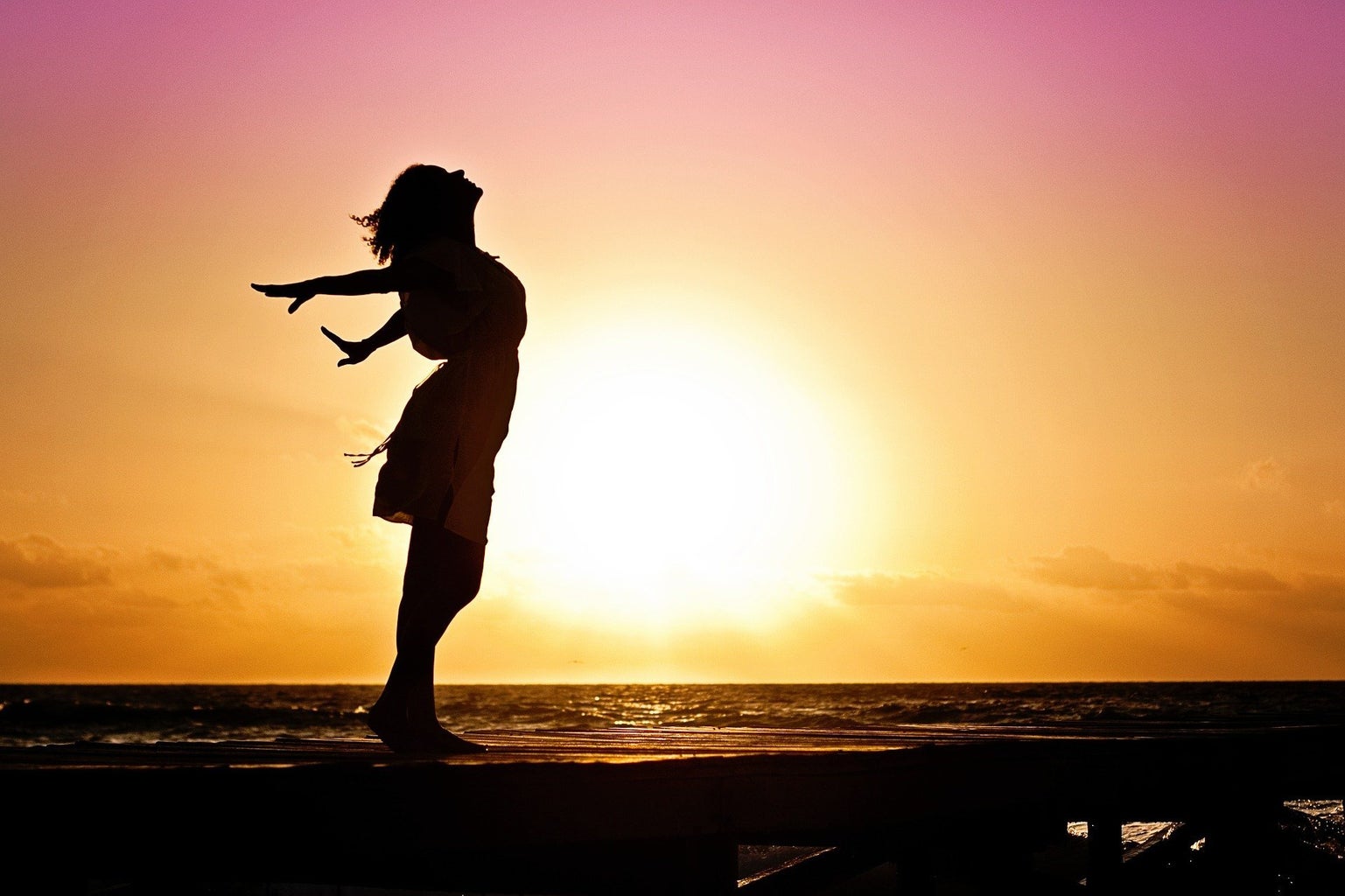 Woman at the beach at sunset