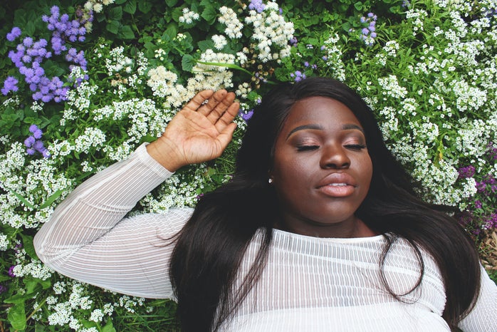 Woman laying on purple and white flowers