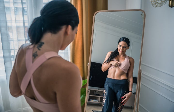 woman in athleisure looking in mirror by Szabolcs Toth?width=719&height=464&fit=crop&auto=webp
