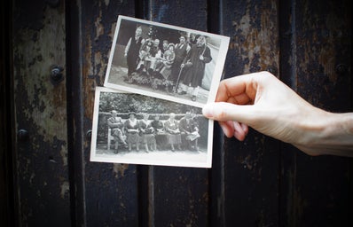 Two old black and white photos being held up