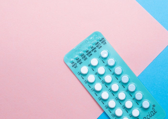 Blue birth control packet with pink background