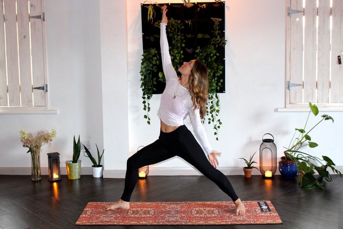 Woman doing yoga with plants and candles by Zen Bear Yoga?width=698&height=466&fit=crop&auto=webp