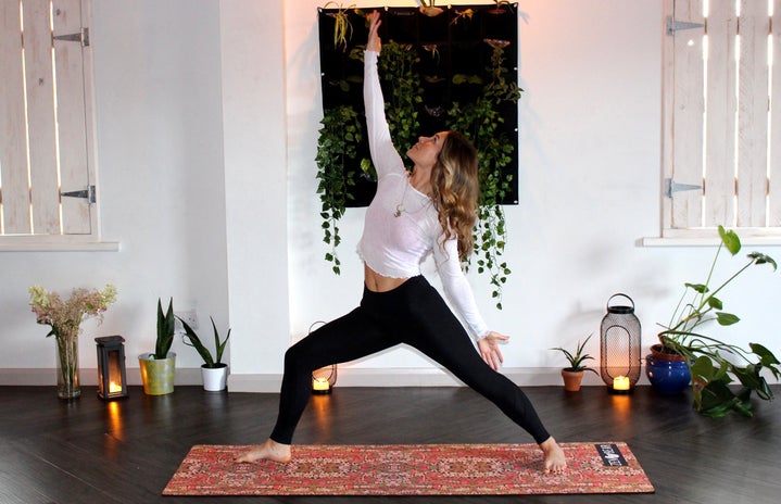 Woman doing yoga with plants and candles by Zen Bear Yoga?width=719&height=464&fit=crop&auto=webp