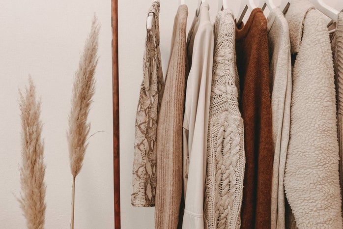 sweaters on clothing rack, sheaf of wheat next to it