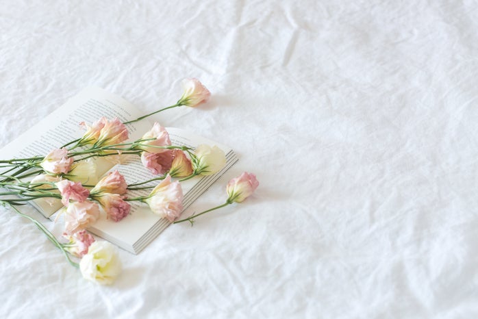 book with pink flowers on white sheets
