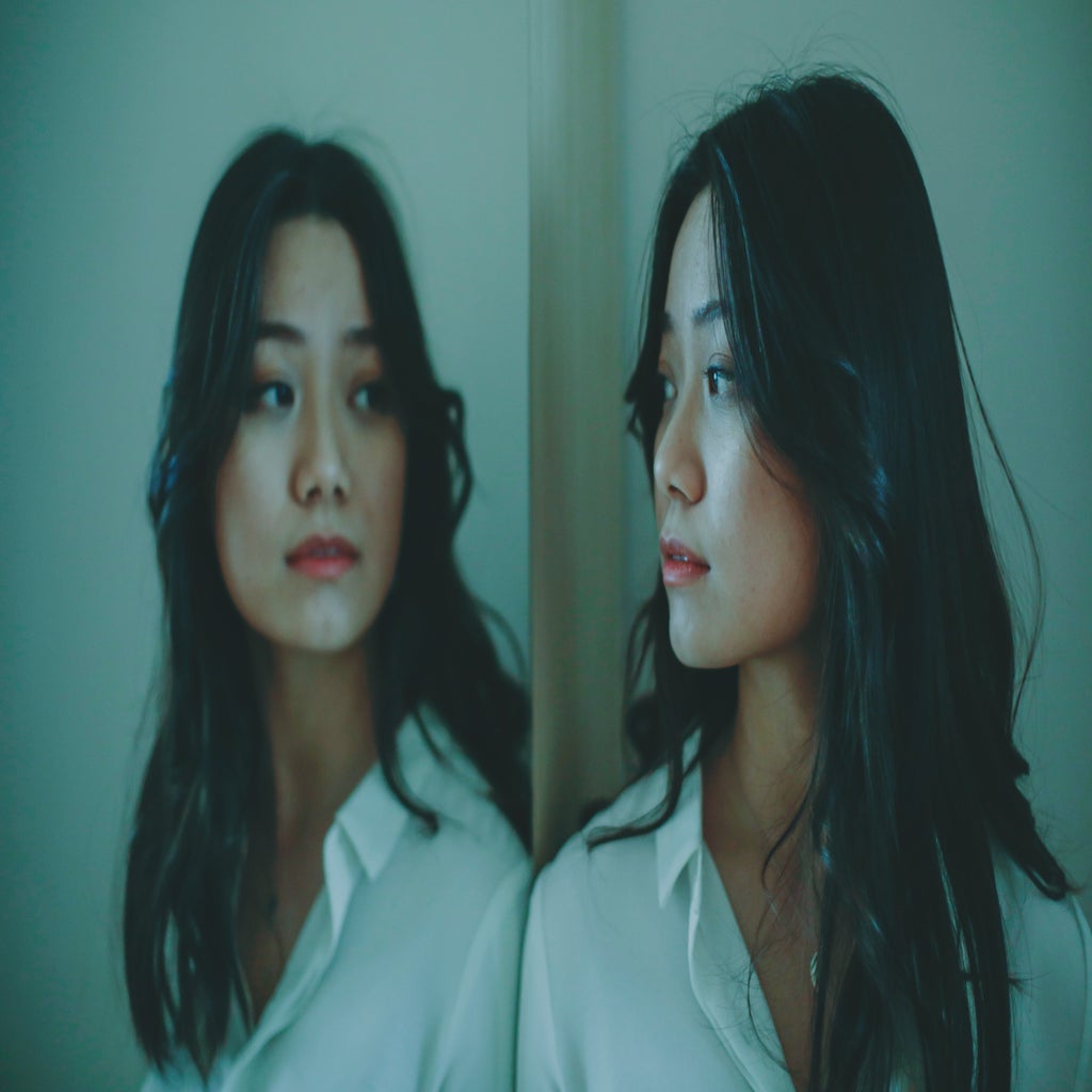 Asian woman looking at reflection